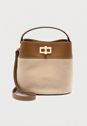 Pieni vaaleanbeige ja ruskea säilytyskori, jossa on nahkainen yläosa, kullanvärinen kiinnitin, lyhyt kahva ja irrotettava pitkä hihna valkoisella taustalla.