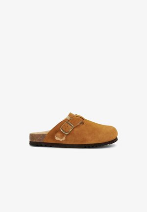 Brune ruskindsklippere med en afrundet tå, justerbar metallås og korksål. Blød foring synlig ved hælen, tekstureret gummi ydersål.