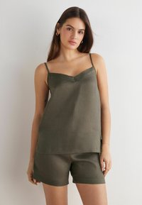 Oliwkowa, bezrękawnikowa, lekka kamizelka z dekoltem w serek i cienkimi ramiączkami, w zestawie z pasującymi szortami z prostym wykończeniem.
