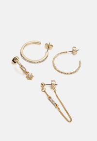 Quatro pares de brincos em tom dourado: dois estilos de argola, um com strass; um design pendente com uma pequena estrela; um detalhe em corrente.