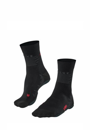 Schwarze Knöchelsocken aus einem atmungsaktiven Stoff. Mit grauen horizontalen Linien und einem roten Logo an der Seite. Strukturierte Sohle für Grip.