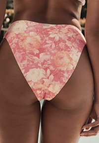 Roževa visoko pasna bikini dno v roza barvi, z mešanico pastelnih cvetov in gladkega, teksturiranega materiala, z brezšivnim zaključkom.