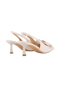 Zapatos de tacón tipo slingback en cuero crema con punta afilada, detalle de lazo y un tacón stiletto blanco de 3 pulgadas con punta marrón. Diseño elegante.