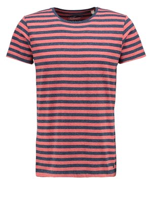 Junger Mann trägt hellblaues Hemd über einem rot-navy gestreiften T-Shirt, hochgekrempelte helle Jeans und graue Stoff-Sneaker, läuft nach vorne.