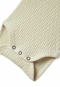 Ribbet kremfarget bodysuit med strukturert stoff, trykknapplukking med svarte detaljer og rund halslinning.