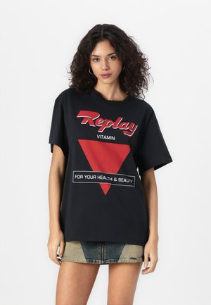 T-shirt nera oversize con stampa grafica rossa con la scritta "Replay" e un design triangolare. Maniche corte e vestibilità ampia.