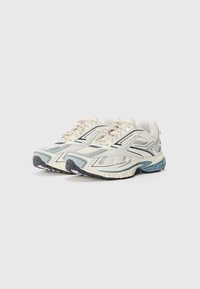 Athletic sneakers in cream and light blue. Mesh and synthetic upper with layered design, textured sole, and minor black accents.
