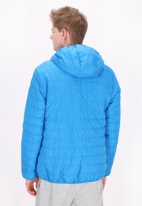 Giacca imbottita blu con cappuccio, caratterizzata da una texture trapuntata e una forma leggermente sagomata. Il materiale è liscio e leggero.