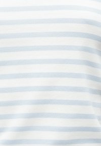 Stripete stoff i hvitt og lyseblått med en ribbet tekstur. Stripene er jevnt fordelt og skaper et subtilt mønster.