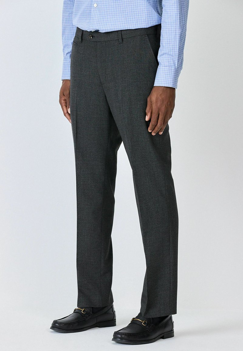 Grey dress pants with a subtle pattern, lightweight fabric, straight cut, and belt loops, paired with black loafers and a blue checkered shirt.