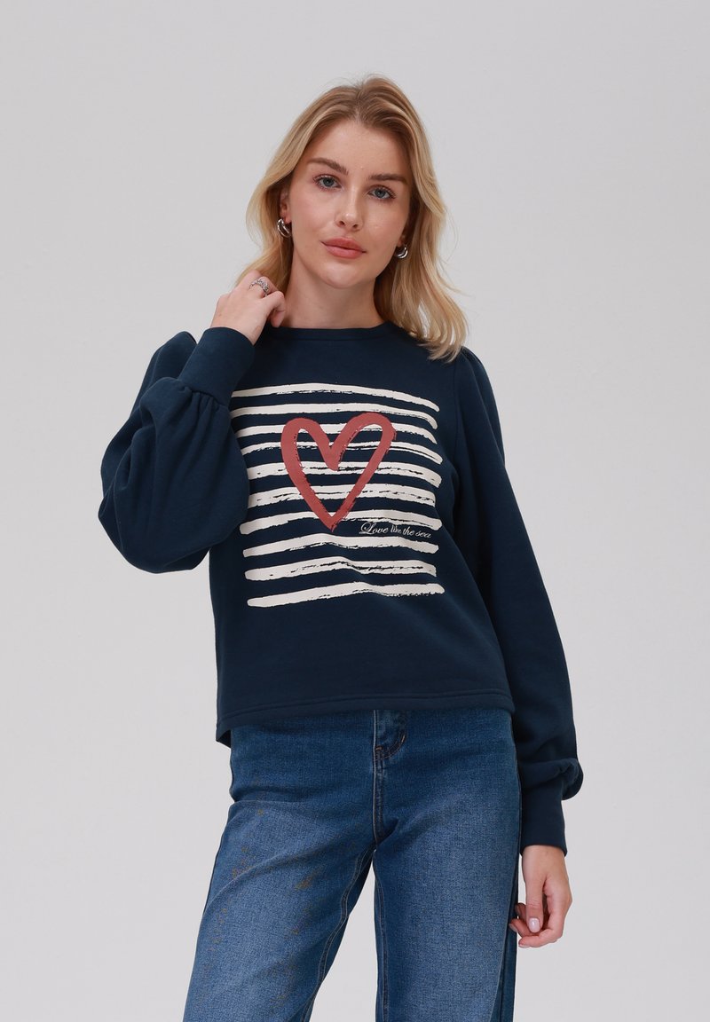 Sweat-shirt bleu marine à col rond, manches bouffantes, avec un motif rayé blanc et un graphique de cœur rouge avec le texte "Amour dans la mer."