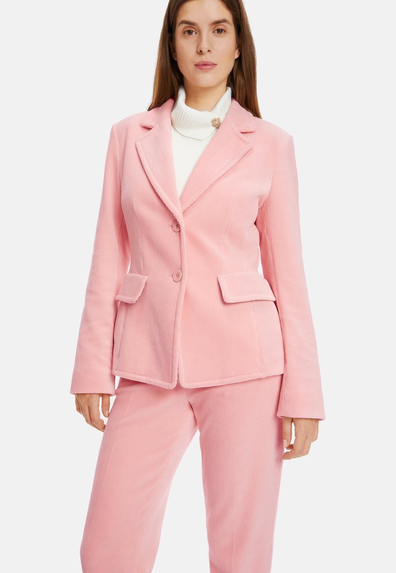 Rosa Cordhosenanzug bestehend aus einem taillierten Blazer mit zwei Knöpfen und passenden Hosen, mit einer subtilen Textur und Fronttaschen.