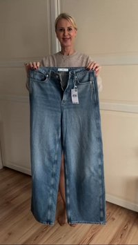 Svijetloplavi traperice širokog kroja s visokom strukom, s prednjim patent-otvaračem, dva džepa i oznakom brenda priloženom.