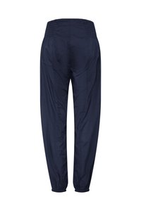 Tamsiai mėlynos laisvo stiliaus kelnės su elastinga juosmens juosta ir apačios manžetėmis, parodytos iš nugaros baltoje fone.