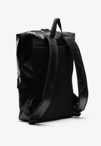 Mochila negra con un exterior brillante y a prueba de agua, y un panel trasero de malla texturizada. Cuenta con correas acolchadas y un asa en la parte superior. Cierre de cremallera.