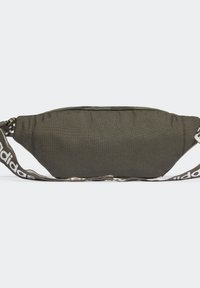 Olivgrön midjeväska med svart dragkedja och justerbar axelrem med vita "adidas"-texter på en ljusgrå bakgrund.