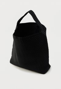 Sac cabas tissé noir avec une forme structurée, une ouverture étroite en haut et une poignée solide. Caractérisé par un matériau texturé et un design sans coutures.