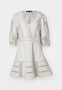 Robe en coton blanc avec un ourlet inférieur texturé, décolleté en V et manches bouffantes. Présente des détails en dentelle complexes et des fermetures à boutons.
