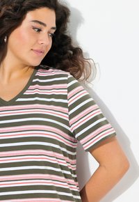 Pruhované tričko s krátkým rukávem a V výstřihem, které má horizontální pruhy v olivově zelené, bílé a červené barvě. Měkká textura a volný střih.