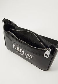 Borsa a tracolla in pelle nera con logo argentato, chiusura con zip e tracolla in tessuto. L'interno presenta una fodera nera e una tasca aggiuntiva.