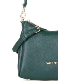 Borsa in pelle verde con fibbia dorata, cerniera e chiusura, con parziale nome del brand "VALENTI" visibile sul davanti.