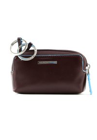 Busta in pelle marrone con zip e accenti blu, dotata di hardware in argento e attacco per portachiavi circolare. Texture liscia.