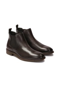 Botas Chelsea de cuero marrón con paneles elásticos en los laterales, punteras redondeadas y acabado texturizado. Tacón bajo apilado y lengüetas para facilitar el uso.