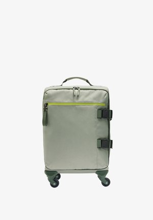 Miękka walizka w jasnym zielonym kolorze z przednią kieszenią na suwak, dwoma bocznymi klamrami, górnym uchwytem i czterema obracającymi się kółkami.