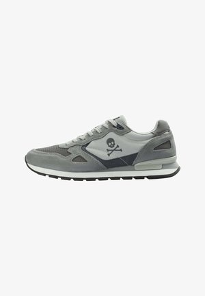Gray sneaker featuring suede and mesh materials, a low-top design, and a skull-and-crossbones logo on the side. Black rubber sole.