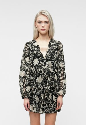Czarna sukienka w kwiaty z kremowymi wzorami, długimi rękawami, głębokim dekoltem w serek, talią podkreśloną w pasie oraz zwiewnym dołem uszyta z lekkiego materiału.