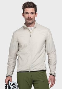 Beige Leichtjacke mit Reißverschluss, hohem Kragen und schwarzem Besatz. Glatte Textur, entworfen für Outdoor-Aktivitäten.