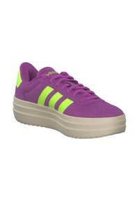 Paarse suède sneaker met een dikke beige zool, voorzien van drie felgroene strepen en bijpassende veters en accenten.