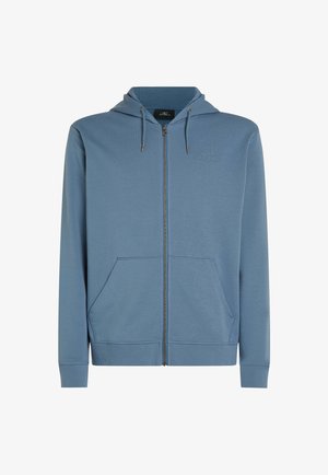 Mėlyna zip-up gobtuvu palaidinė su tekstūruotu audiniu, priekinėmis kišenėmis ir raišteliu ant gobtuvo. Įtraukta subtili logo ant krūtinės ir nėriniuotos rankovės.