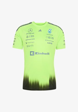 Maglietta da corsa verde neon con sfumatura nera nella parte inferiore e diversi loghi di sponsor tra cui Mercedes AMG, Petronas, INEOS, UBS ed Einhell.
