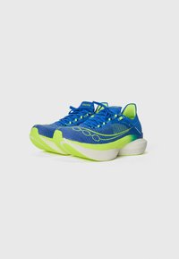 Blue running shoes with a textured mesh upper, green accents, a cushioned sole, and a distinctive curved design for enhanced performance.