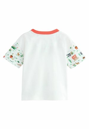 Camiseta blanca de manga corta; cuello de canalé color coral; las mangas presentan patrones coloridos de animales y naturaleza sobre un fondo claro.