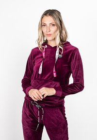 Syväpurppura samettinen huppari, jossa on kengurupocket, nauhat brändin logolla ja pehmeä rakenne.