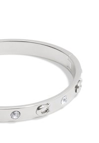 Silver metal bracelet with a smooth finish, featuring clear rhinestones and a clasp detail, exhibiting a sleek, rounded design.