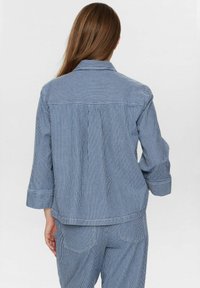 Randig blå och vit oversized jacka med krage, trekvartsärmar och avslappnad passform, med en veck bak.