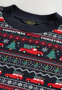 Maglione di Natale rosso e blu navy con alberi, camion e fiocchi di neve in un motivo a maglia. Collo a coste, elementi di design festivi in tutta la sua lunghezza.