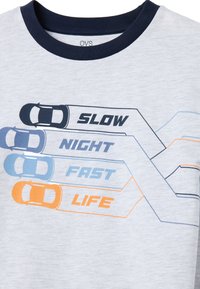 Camiseta de color gris claro con cuello redondo azul marino, que presenta un texto gráfico: "LENTO", "NOCHE", "RÁPIDO", "VIDA", junto a varios gráficos de coches en diferentes colores.