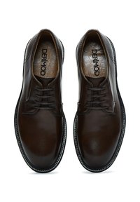 Zapatos de cuero marrón oscuro con una textura suave, punta redondeada y diseño de cordones. Presentan una suela cosida en color contrastante y una plantilla con la marca.