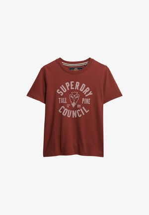 T-shirt rossa in cotone con maniche corte e scollatura rotonda. Presenta una stampa grafica bianca che include "SUPERDRY COUNCIL" e un design a scudo.