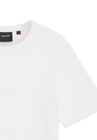 Witte korte mouwen t-shirt van een gestructureerde stof. Heeft een ronde halslijn en een zwart label met het merk "LYLE & SCOTT" aan de binnenkant van de hals.