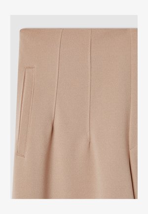 Beżowe spodnie o kroju dopasowanym z gładką fakturą, z bocznymi kieszeniami i pionowymi szwami dla uzyskania uporządkowanego wyglądu.