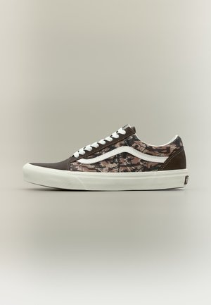Basket basse avec semelle et lacets blancs, bout et talon marron foncé, côtés à motifs floraux marron, noir et beige avec une bande blanche.