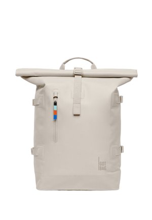 Beżowy plecak z rolowanym zamknięciem, przednią pionową kieszenią na suwak, kolorowym uchwytem suwaka, górną rączką, bocznymi paskami i logo „GOT BAG.” na dole po prawej stronie.