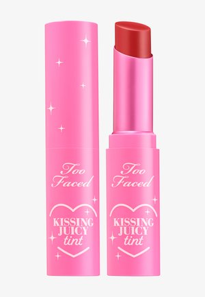 Rouge à lèvres tube rose avec finition brillante, étiqueté "Too Faced Kissing Juicy Tint." Bille rouge à l'intérieur, avec de subtils accents d'étoiles.