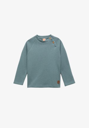 Langarmshirt in gedempte teal met een geribbelde textuur, voorzien van een ronde halslijn, twee oranje knopen op de schouder en een bruine logo patch.