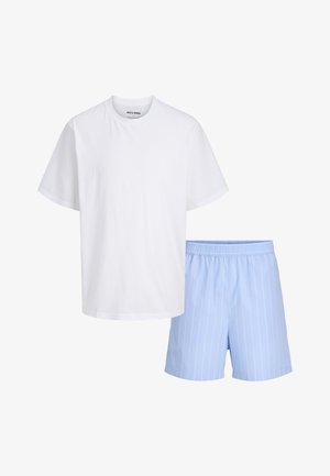 Fehér rövid ujjú póló világoskék rövidnadrággal párosítva, mely vékony fehér függőleges csíkokat és rugalmas derékpántot tartalmaz.